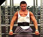 Athlete doing heavy particial deadlifts in a rack.
